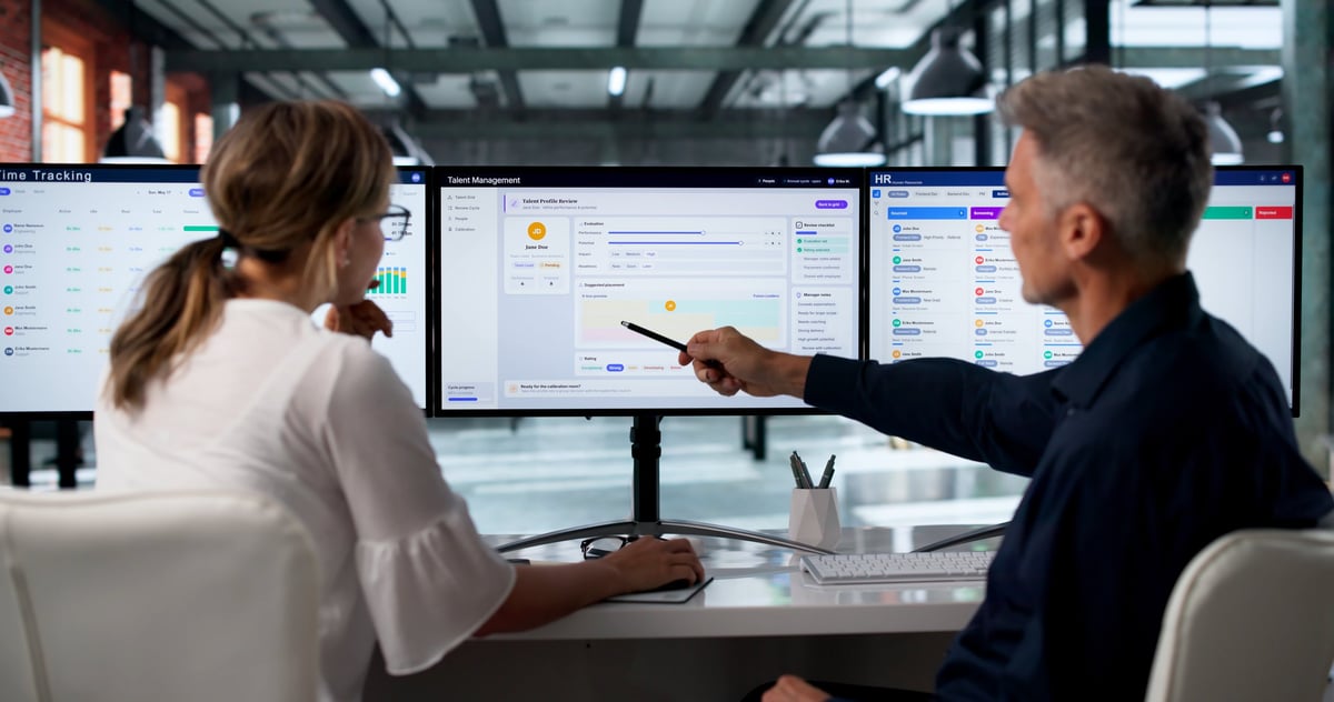 Two managers reviewing schedules and performance data on computers
