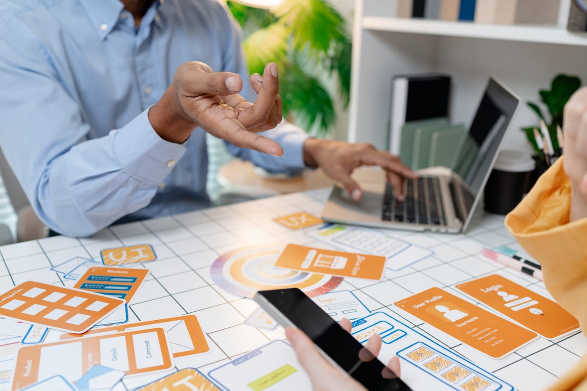 Designer presenting wireframes and interface layouts during a collaborative workshop